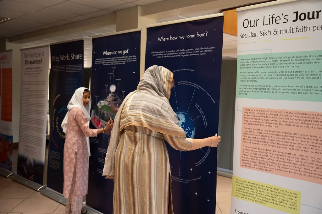 A young girl and older female arranging exhibition panels